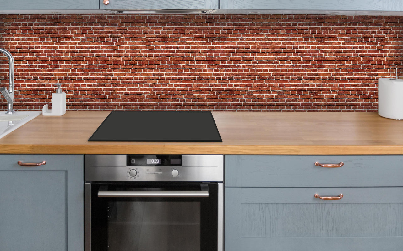 Küche - Alter rote Backsteinmauer über polierter Holzarbeitsplatte mit Cerankochfeld