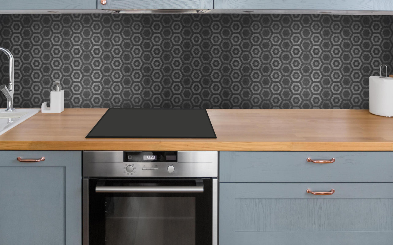 Küche - Anthrazit graue sechseckige Mustern über polierter Holzarbeitsplatte mit Cerankochfeld