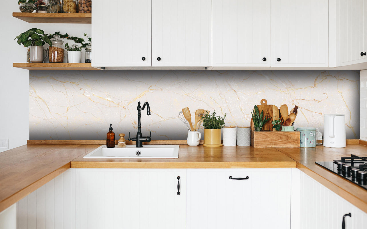 Küche - Beigefarbiger Marmor in weißer Küche hinter Gewürzen und Kochlöffeln aus Holz