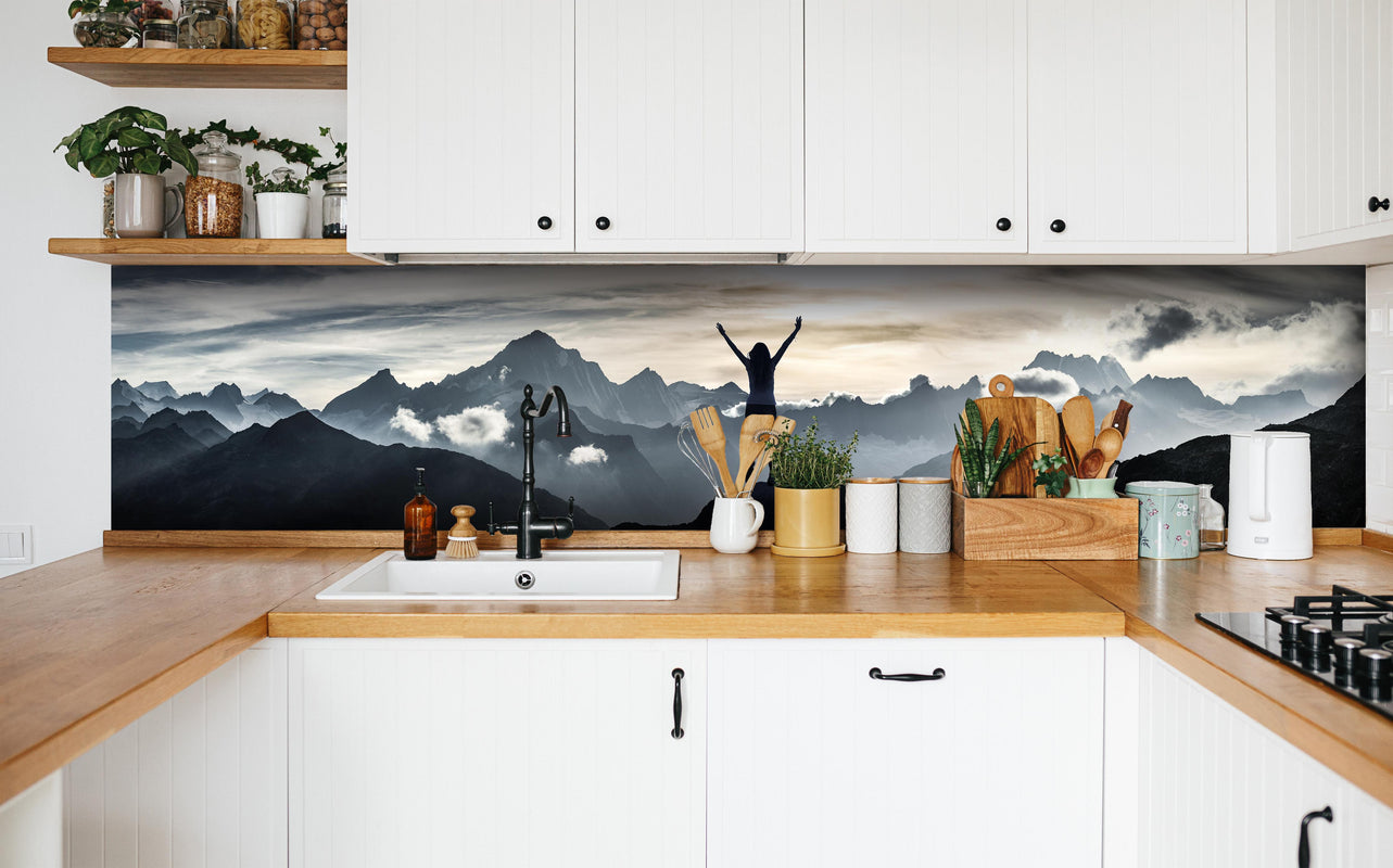 Küche - Bergsteigerin am Gipfel in weißer Küche hinter Gewürzen und Kochlöffeln aus Holz