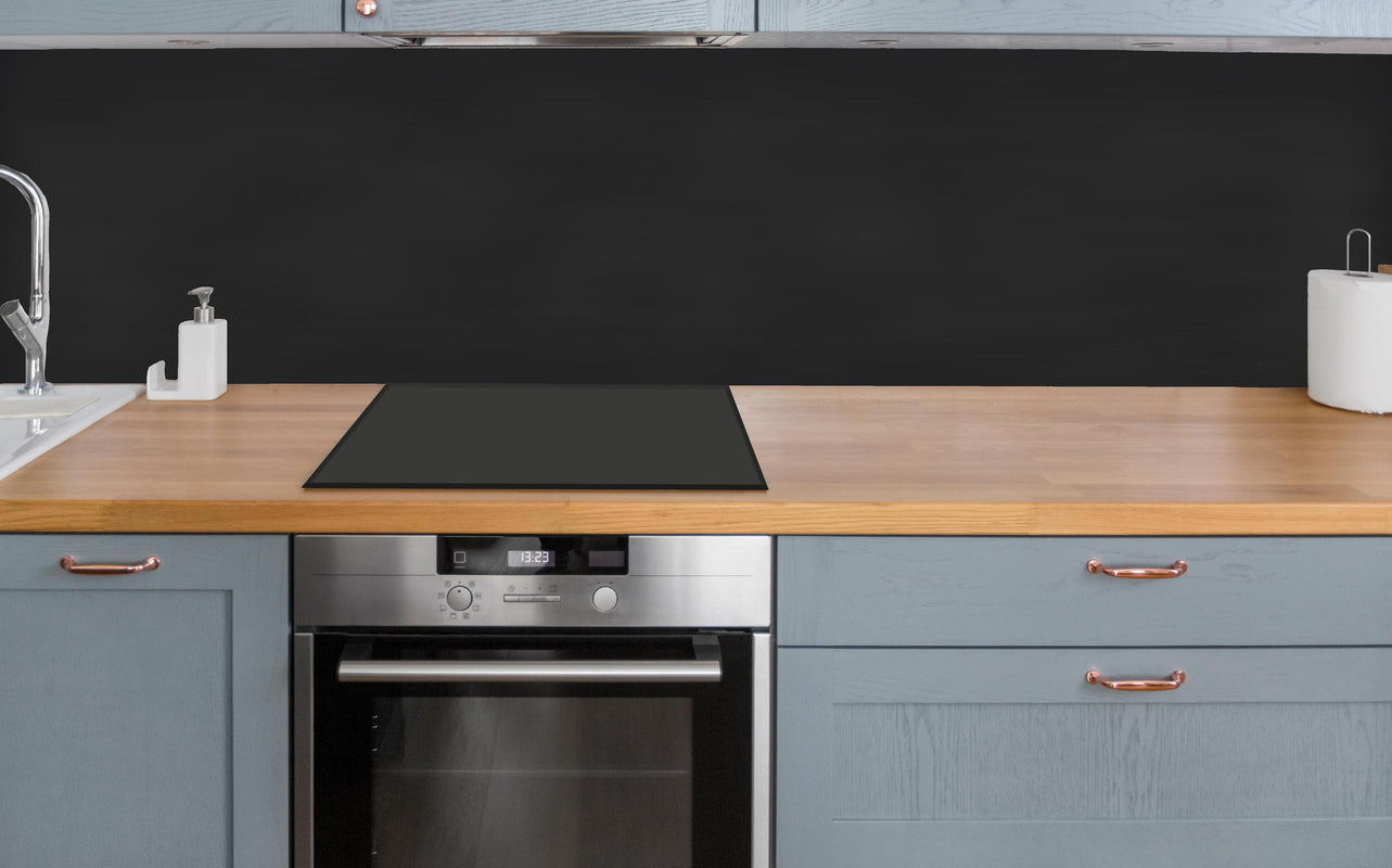Küche - Blankes schwarzes Brett über polierter Holzarbeitsplatte mit Cerankochfeld