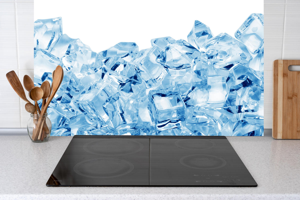 Küche - Blau kristallklarer Eiswürfel hinter Cerankochfeld und Holz-Kochutensilien