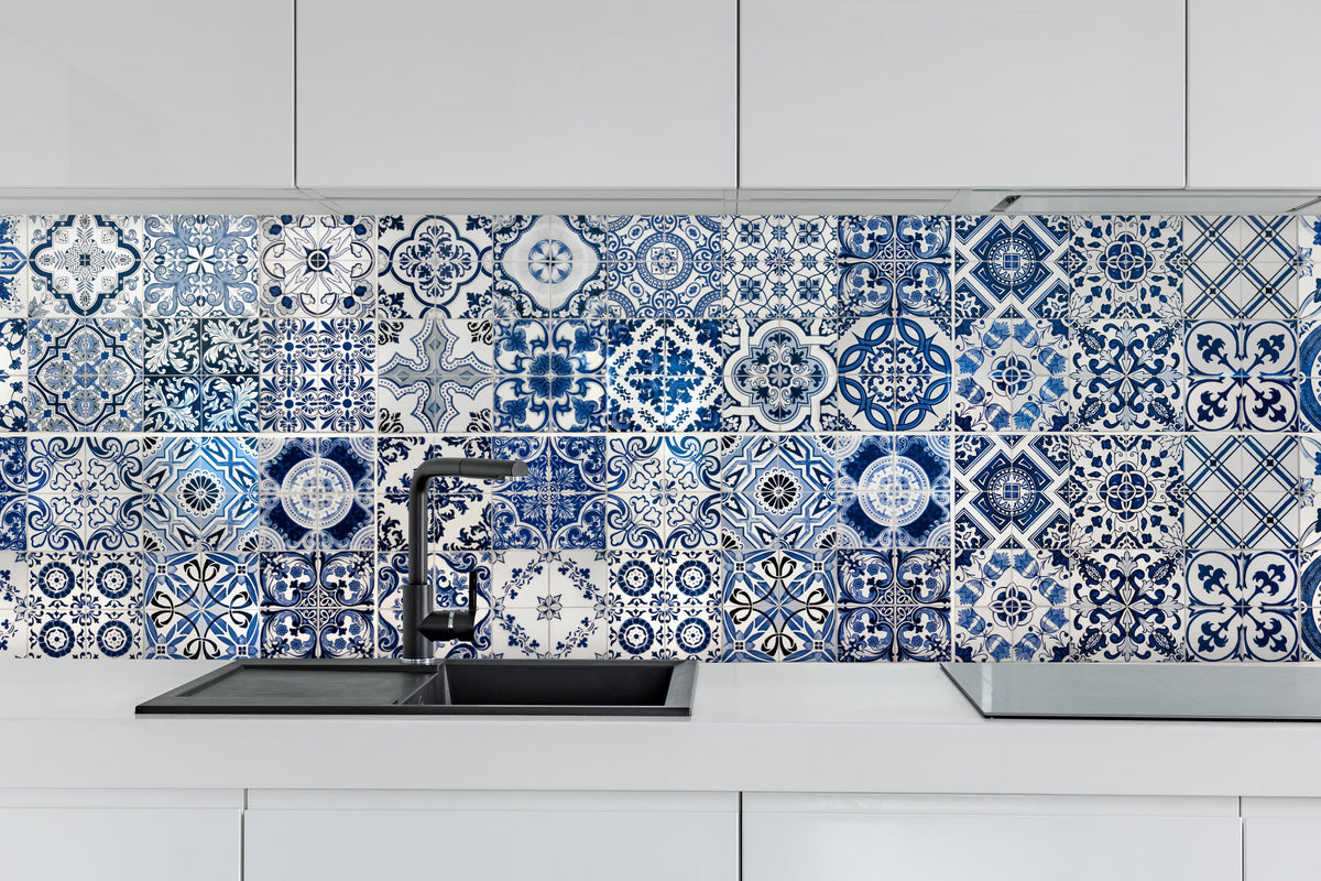 Küche - Blaue portugiesische Azulejo-Fliesen hinter weißen Hochglanz-Küchenregalen und schwarzem Wasserhahn