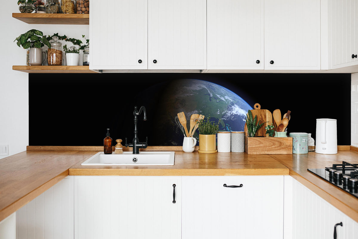 Küche - Blick auf die Erde vom Weltall in weißer Küche hinter Gewürzen und Kochlöffeln aus Holz