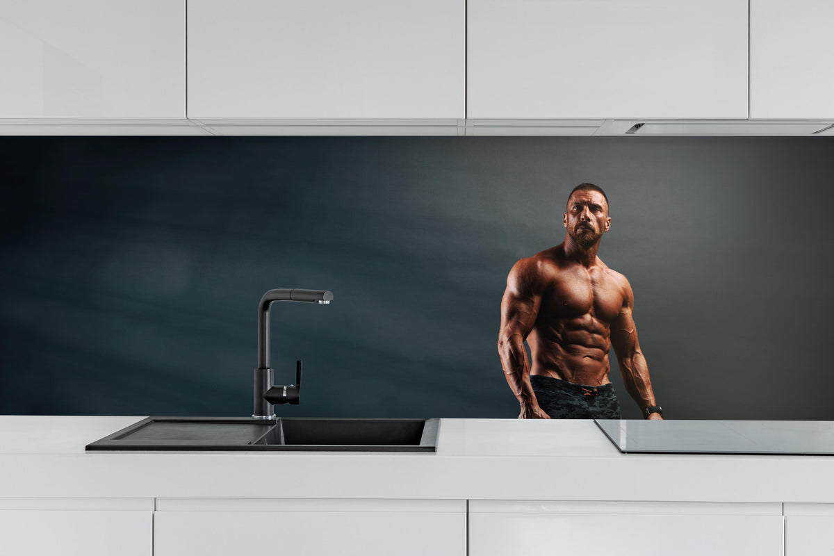 Küche - Bodybuilder - Training hinter weißen Hochglanz-Küchenregalen und schwarzem Wasserhahn