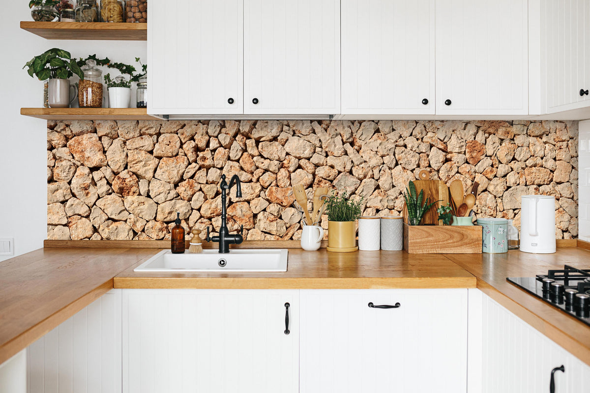 Küche - Bräunliche Panorama-Textur Steinmauer in weißer Küche hinter Gewürzen und Kochlöffeln aus Holz