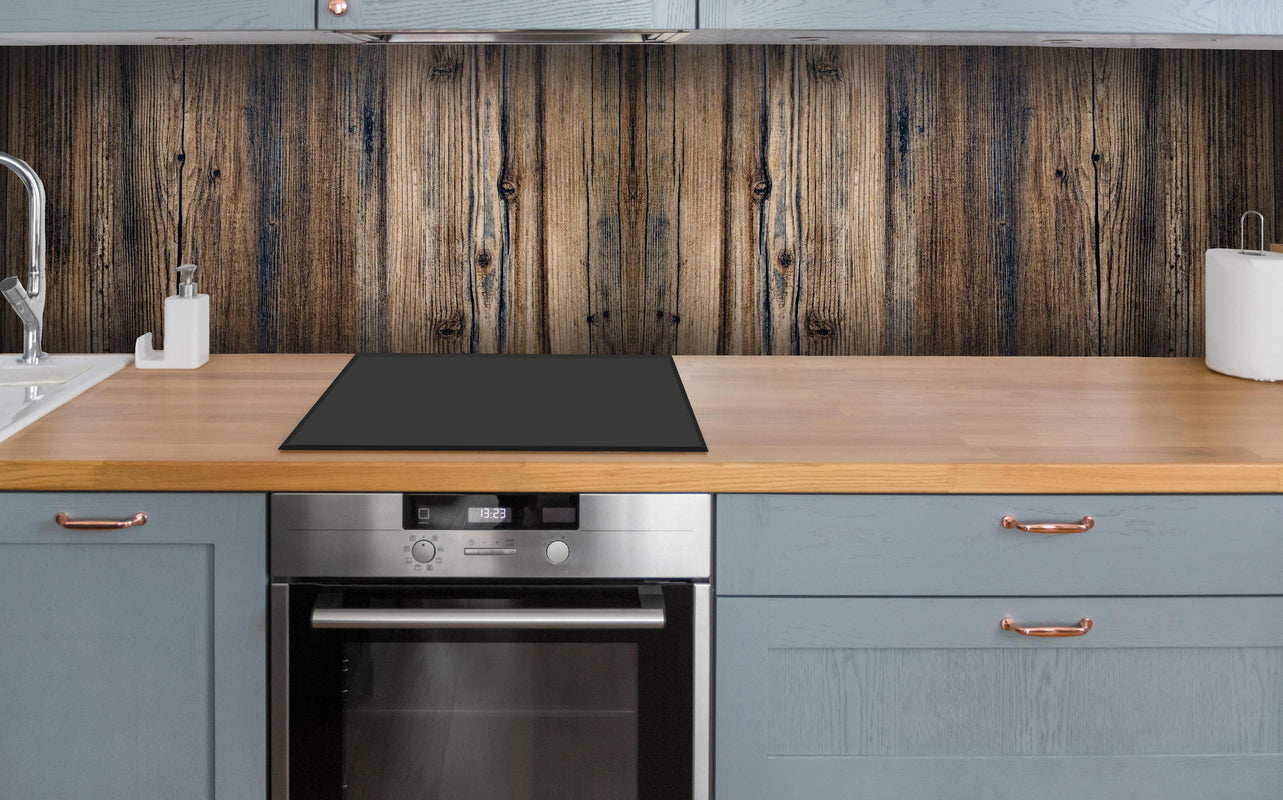 Küche - Bräunlicher Holz Hintergrund über polierter Holzarbeitsplatte mit Cerankochfeld