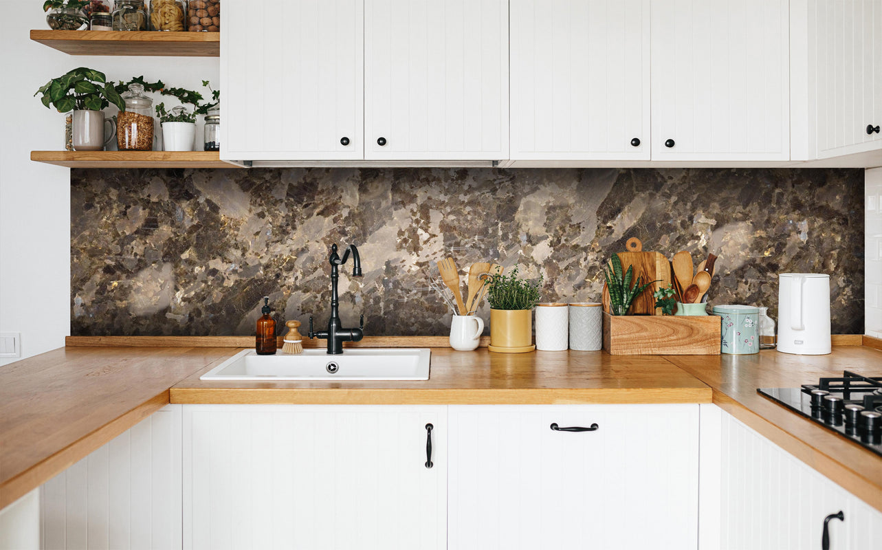Küche - Brauner Marmor in weißer Küche hinter Gewürzen und Kochlöffeln aus Holz