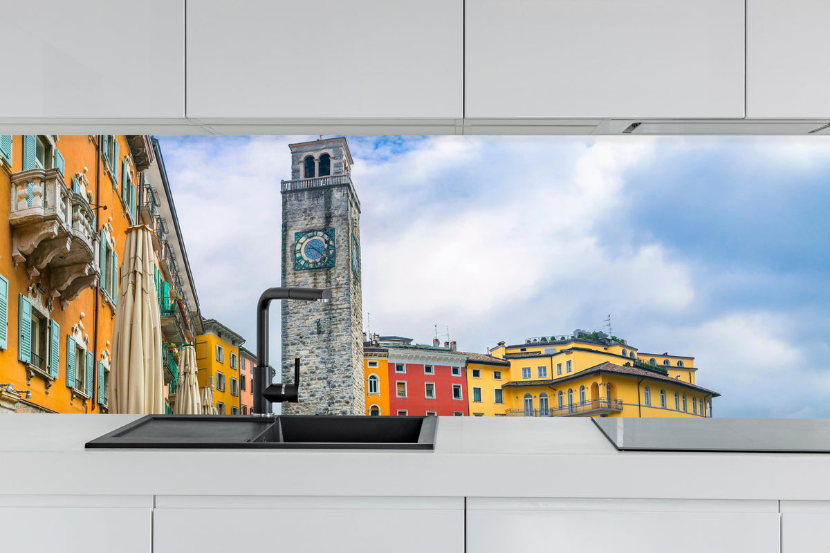 Küche - Charmante Stadt am Gardasee - Riva del Garda hinter weißen Hochglanz-Küchenregalen und schwarzem Wasserhahn