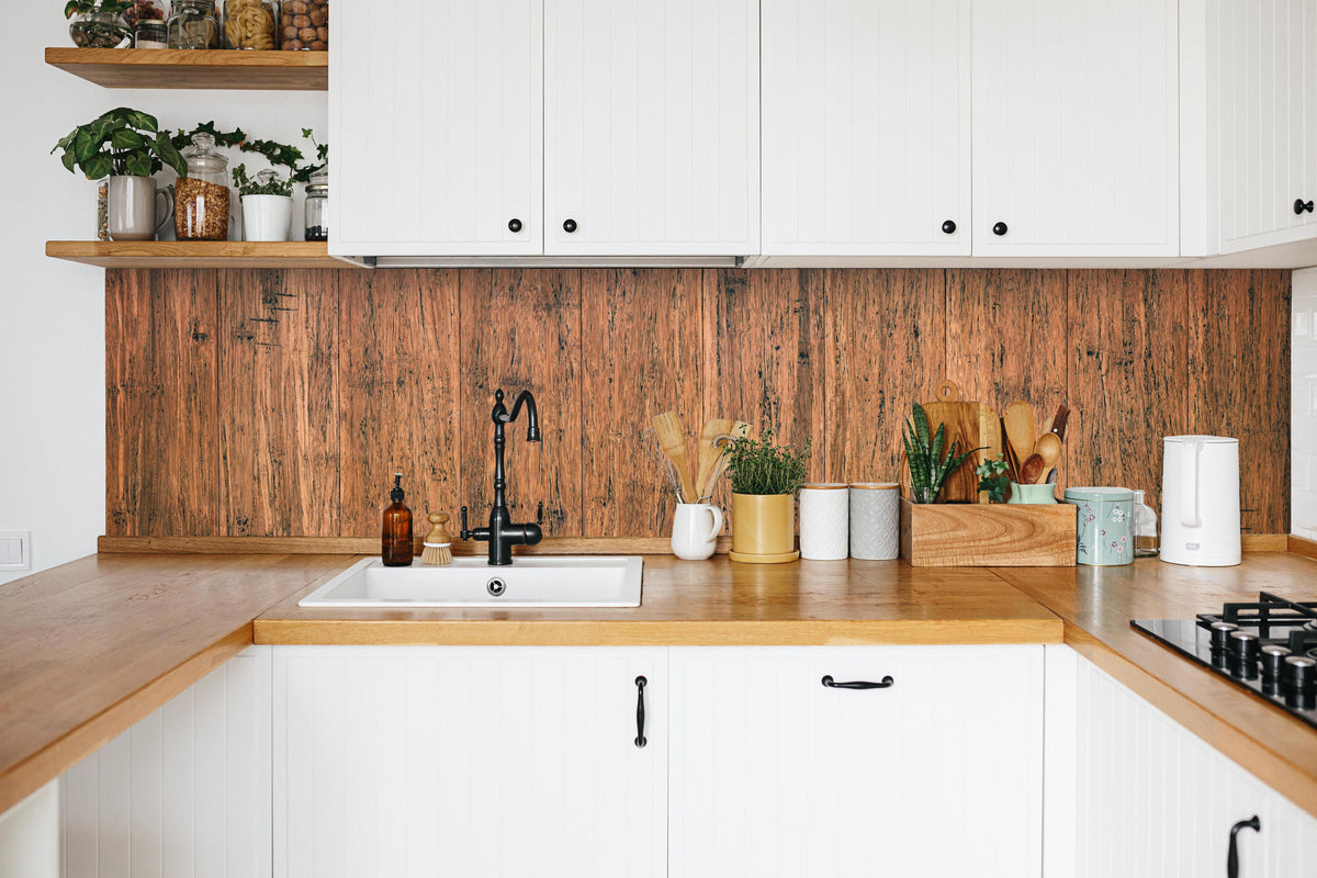 Küche - Dunkelbraunes rustikales Holzbrett in weißer Küche hinter Gewürzen und Kochlöffeln aus Holz