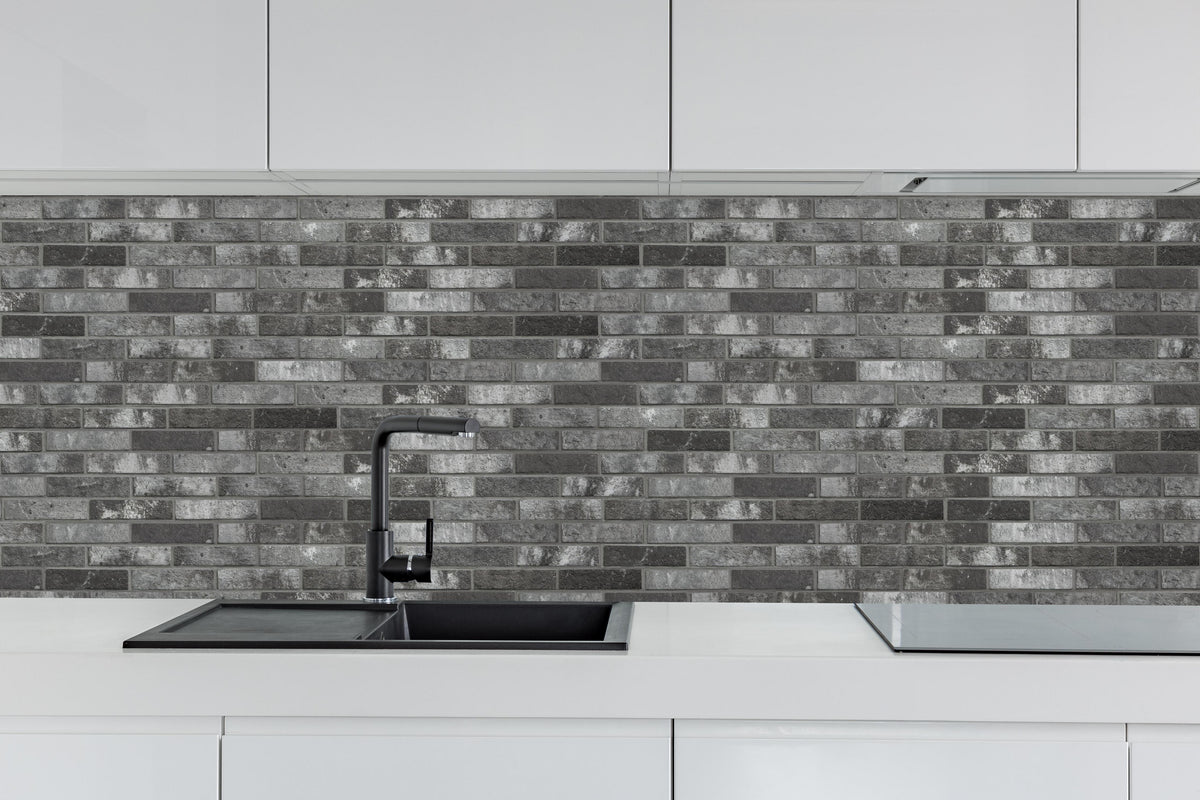 Küche - Dunkelgraue Backsteinmauer hinter weißen Hochglanz-Küchenregalen und schwarzem Wasserhahn