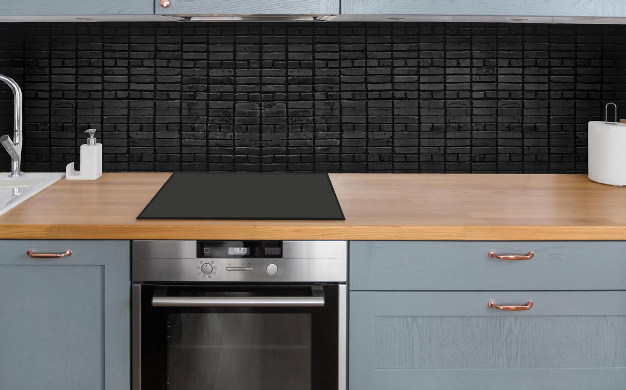Küche - Dunkelgraue Panorama Mauerwerk über polierter Holzarbeitsplatte mit Cerankochfeld