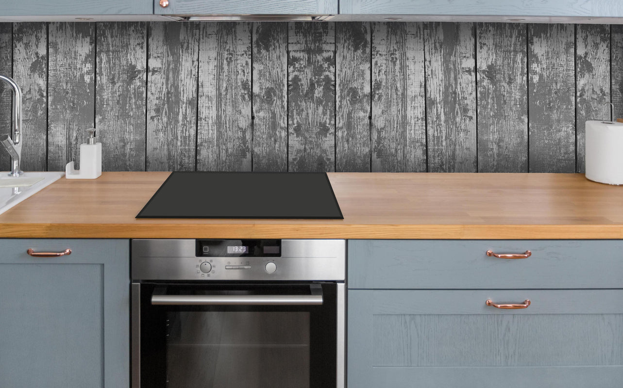 Küche - Dunkelgrauer Holzhintergrund über polierter Holzarbeitsplatte mit Cerankochfeld