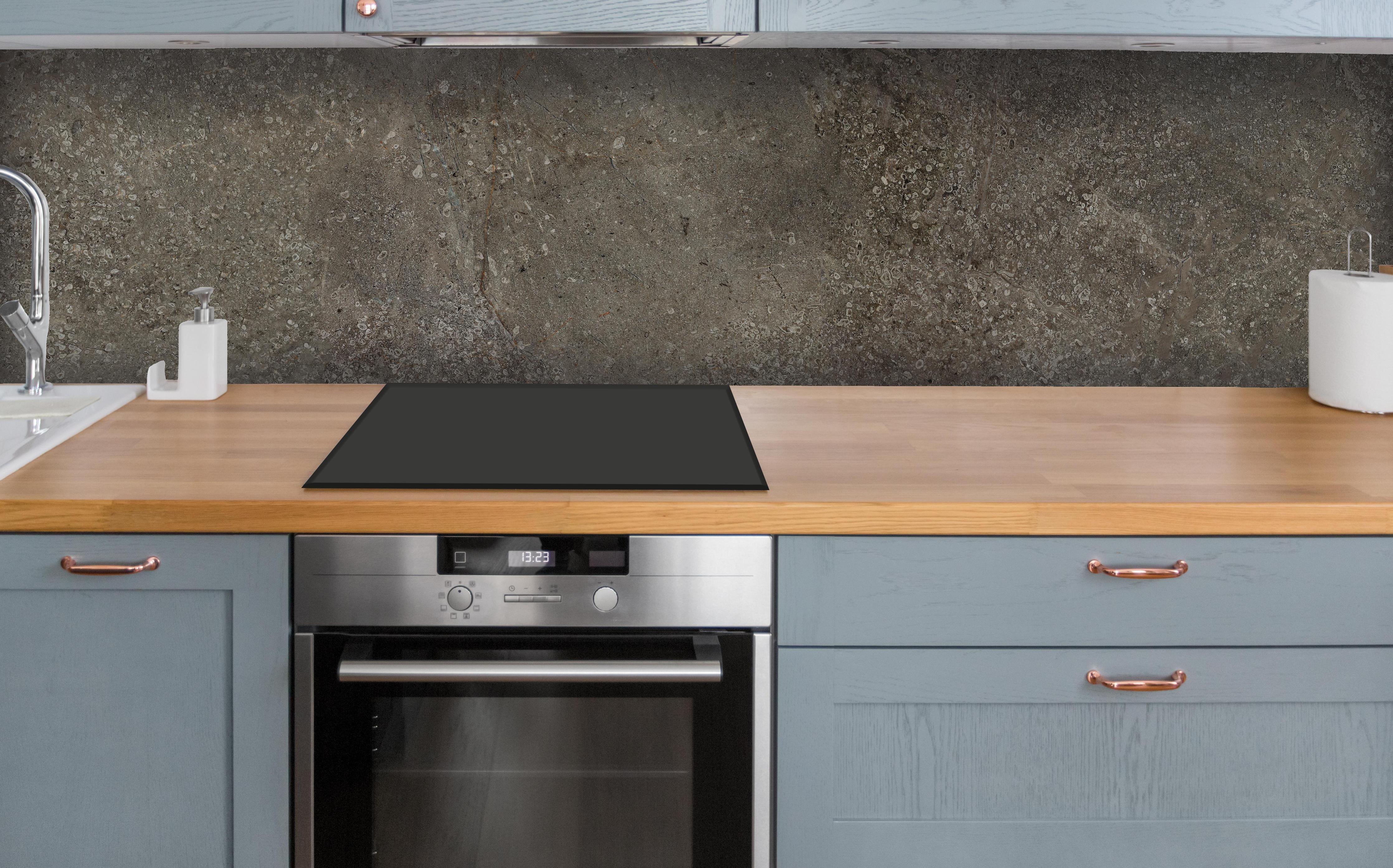 Küche - Dunkelgrauer schwarzer Schieferhintergrund über polierter Holzarbeitsplatte mit Cerankochfeld