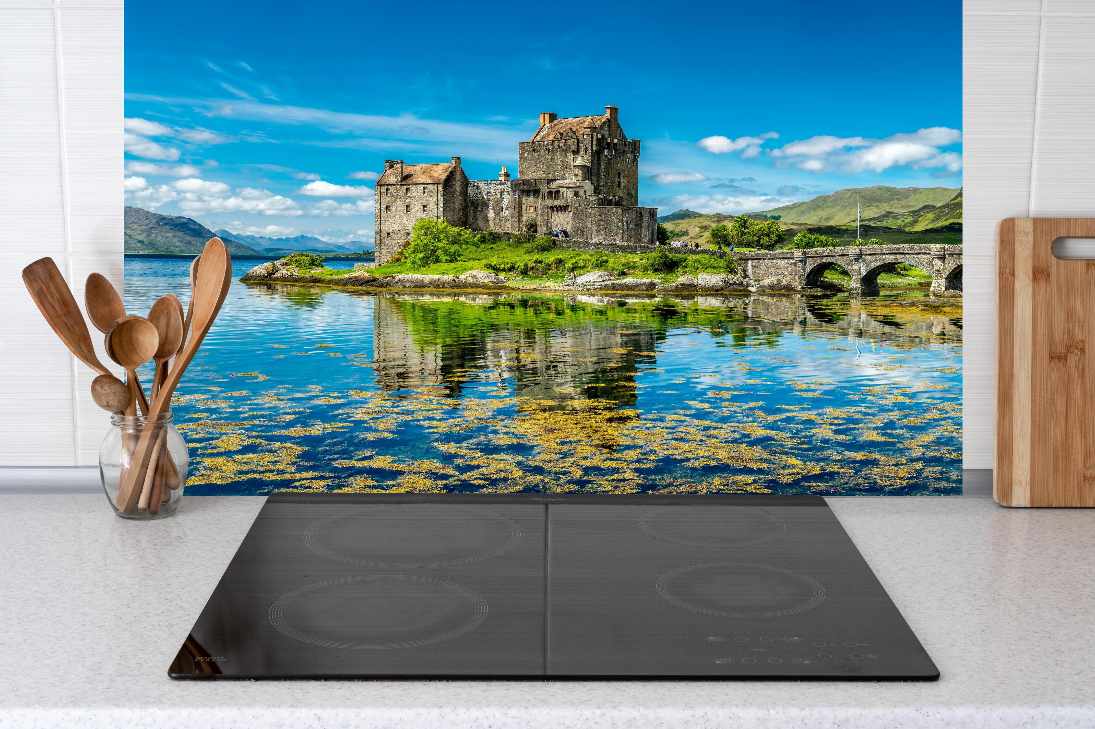 Küche - Eilean Donan Castle hinter Cerankochfeld und Holz-Kochutensilien