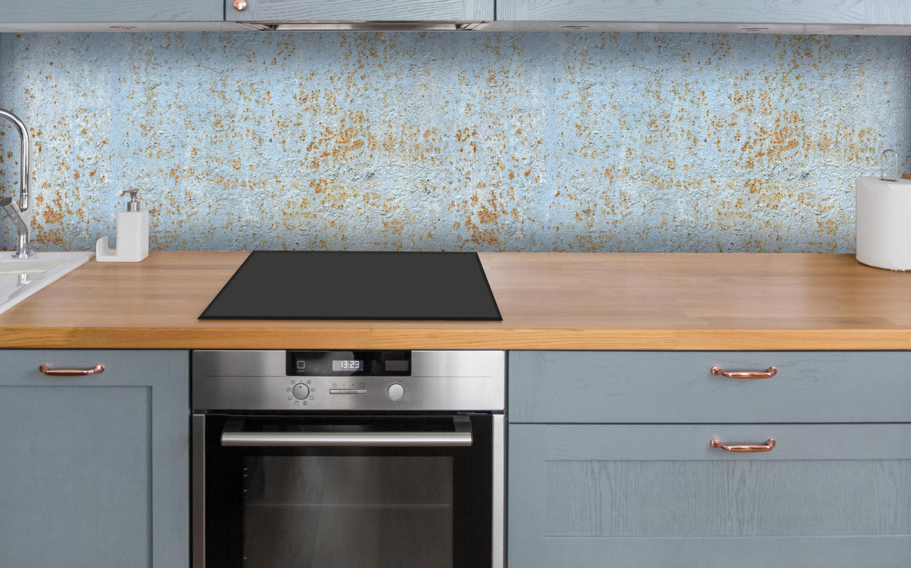 Küche - Farbflocken auf rostigem Metallblech über polierter Holzarbeitsplatte mit Cerankochfeld