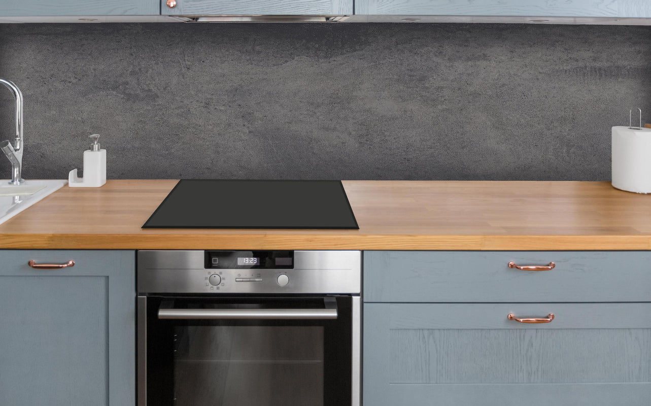 Küche - Feine dunkle Betonwand über polierter Holzarbeitsplatte mit Cerankochfeld