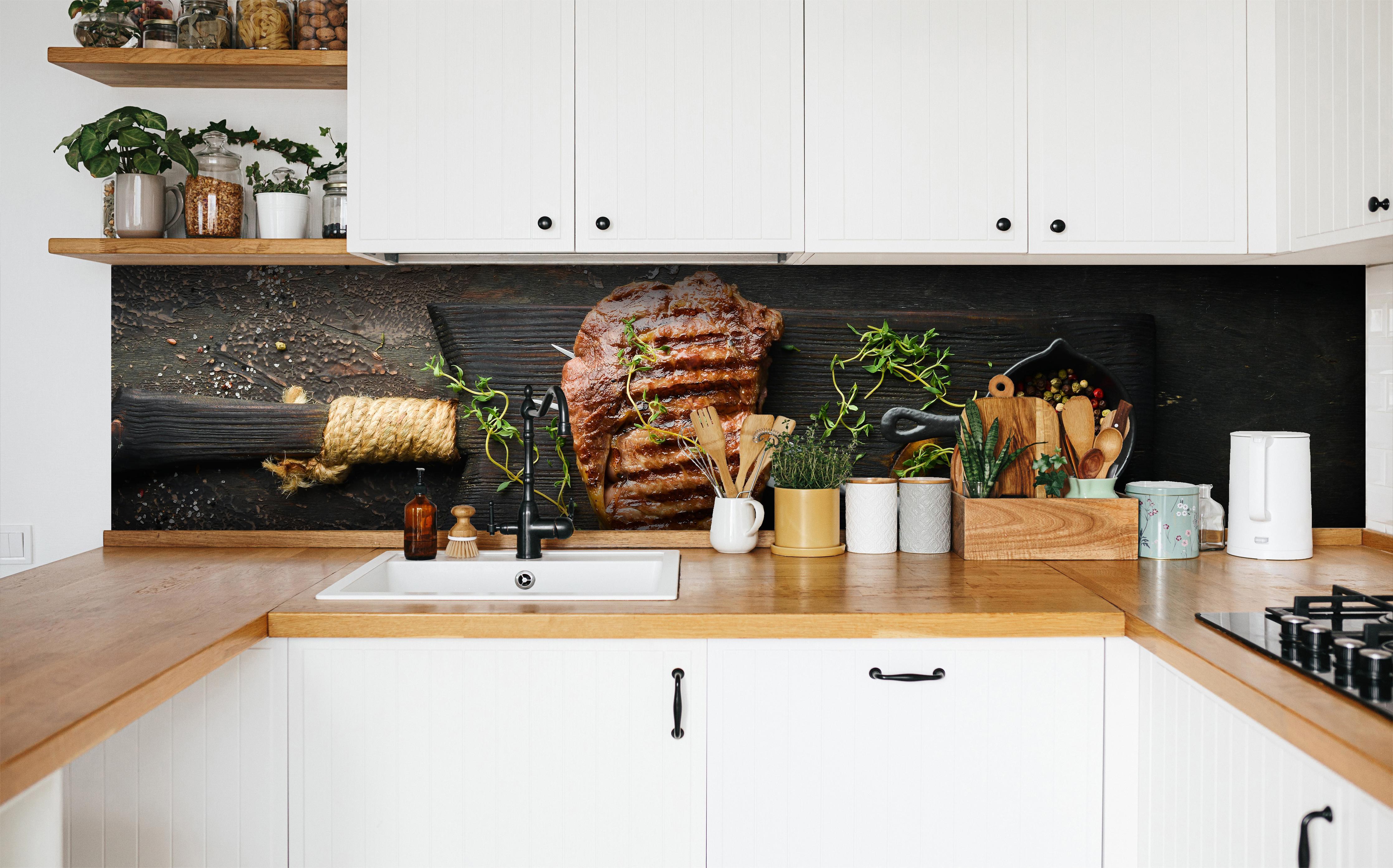 Küche - Gegrilltes Ribeye auf Holzplatte in weißer Küche hinter Gewürzen und Kochlöffeln aus Holz