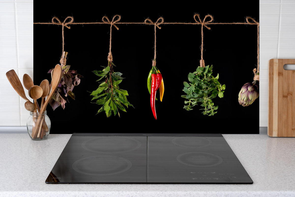 Küche - Gemüse & Kräuter aufgehängt hinter Cerankochfeld und Holz-Kochutensilien