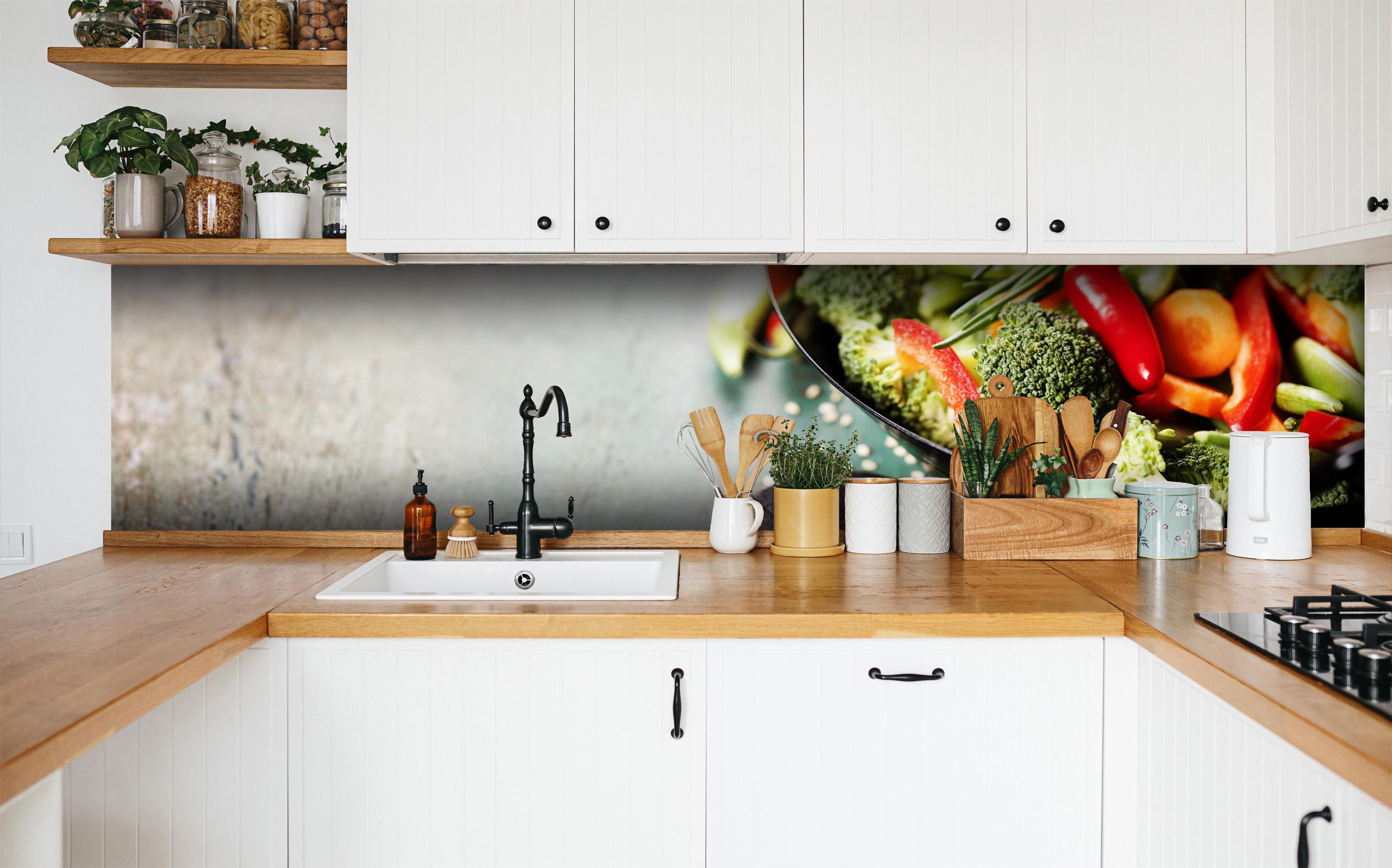 Küche - Gemüse kochen im Wok in weißer Küche hinter Gewürzen und Kochlöffeln aus Holz