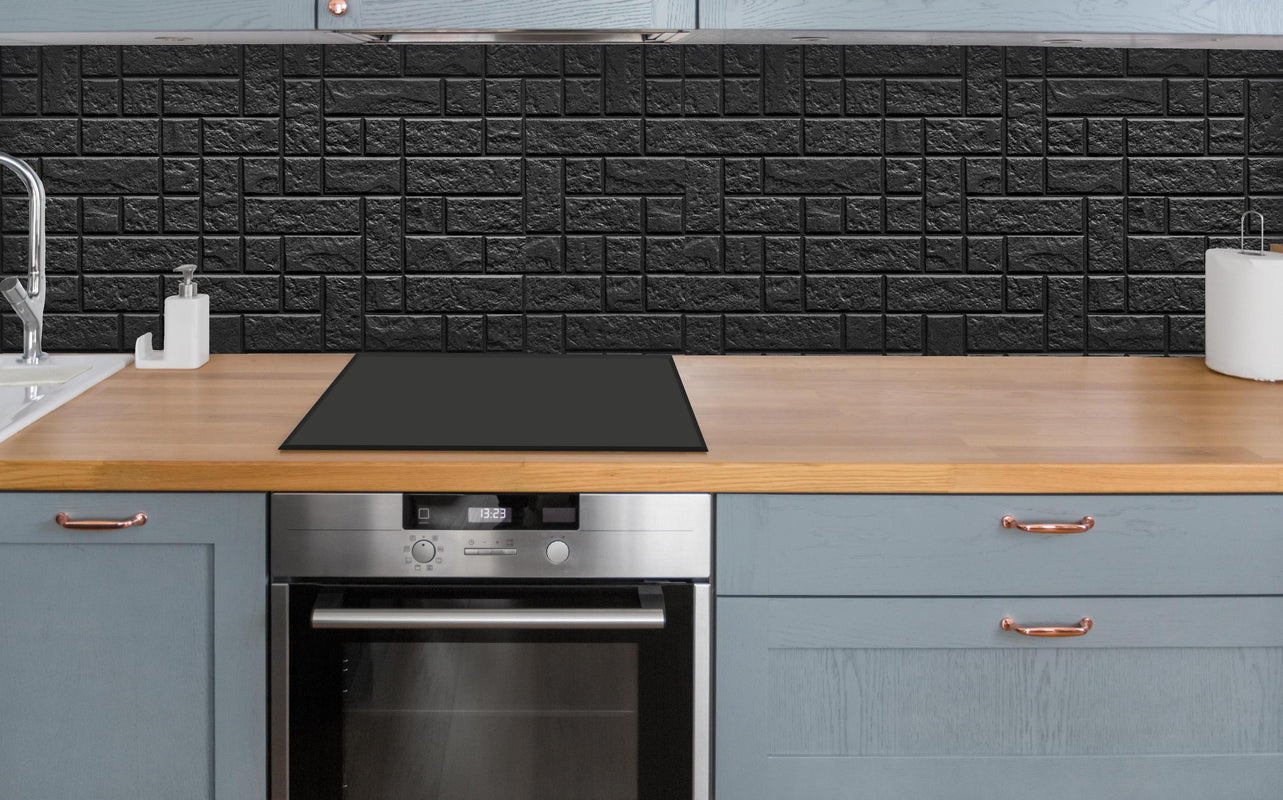 Küche - Geometrisches dunkles Wandfliesendesign über polierter Holzarbeitsplatte mit Cerankochfeld