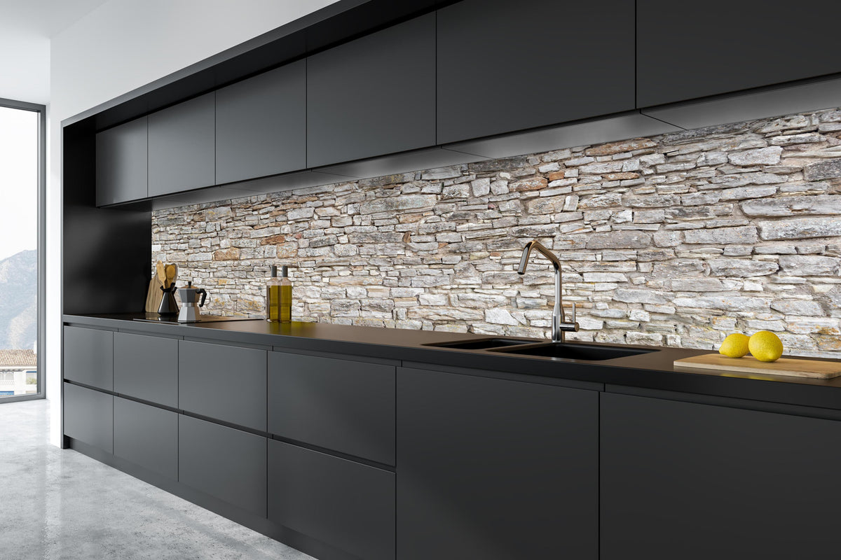 Küche - Gräuliche alte Mauer aus groben Steinen in tiefschwarzer matt-premium Einbauküche