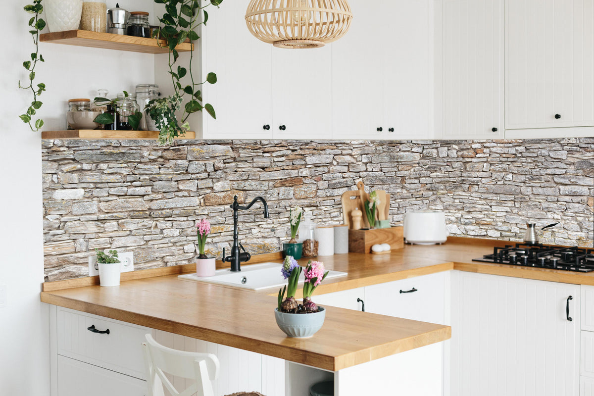 Küche - Gräuliche alte Mauer aus groben Steinen in lebendiger Küche mit bunten Blumen