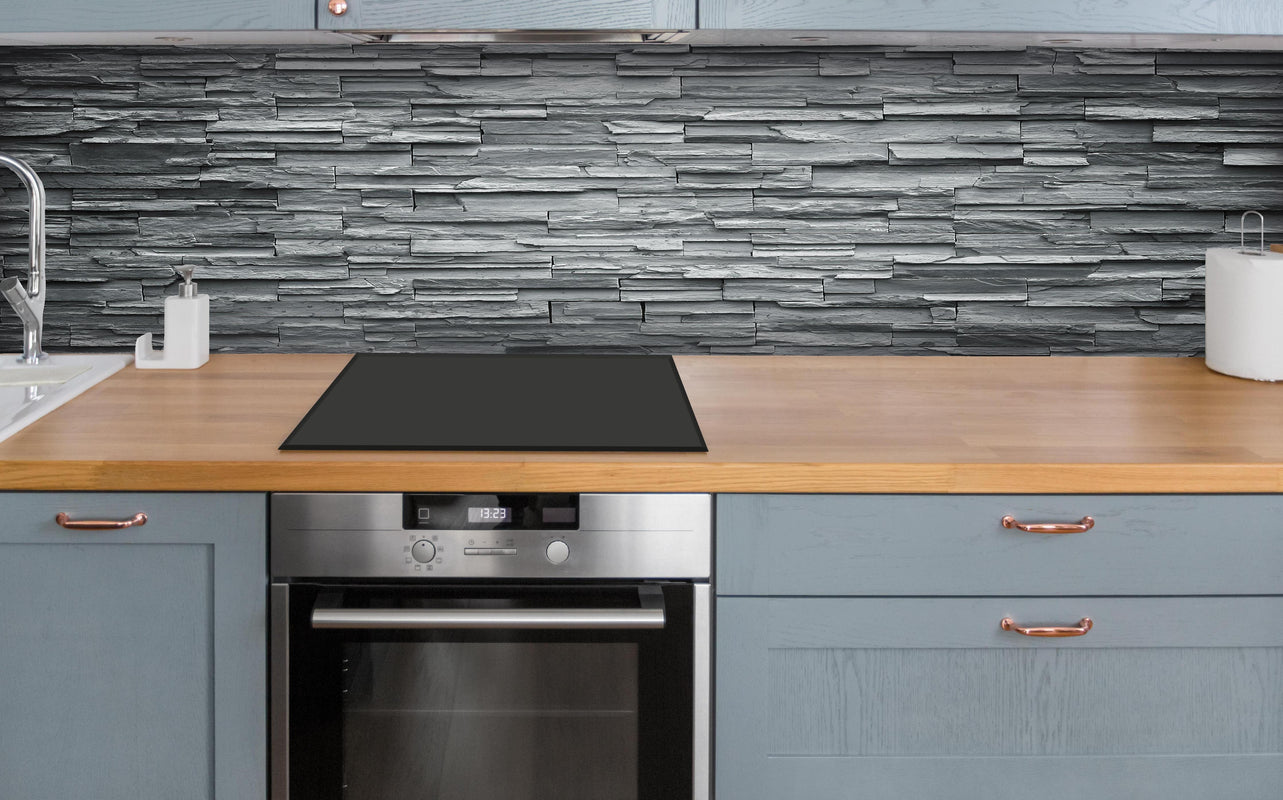 Küche - Graue Steinziegel über polierter Holzarbeitsplatte mit Cerankochfeld