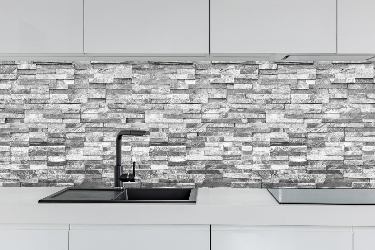Küche - Graue moderne Ziegelwand hinter weißen Hochglanz-Küchenregalen und schwarzem Wasserhahn