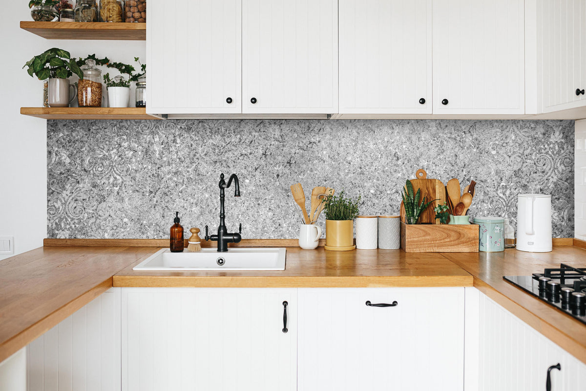 Küche - Graue schäbige Betonwand in weißer Küche hinter Gewürzen und Kochlöffeln aus Holz