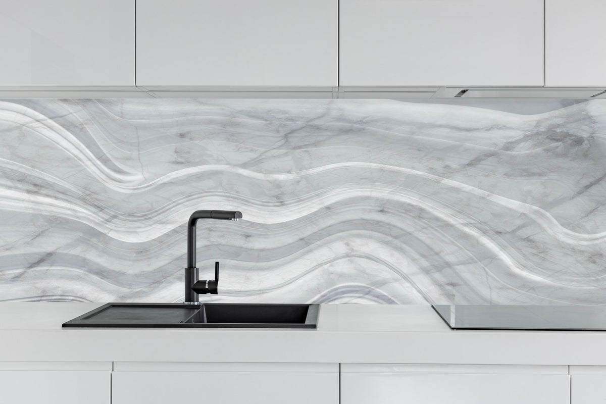 Küche - Graue wellenförmige Marmor Textur hinter weißen Hochglanz-Küchenregalen und schwarzem Wasserhahn
