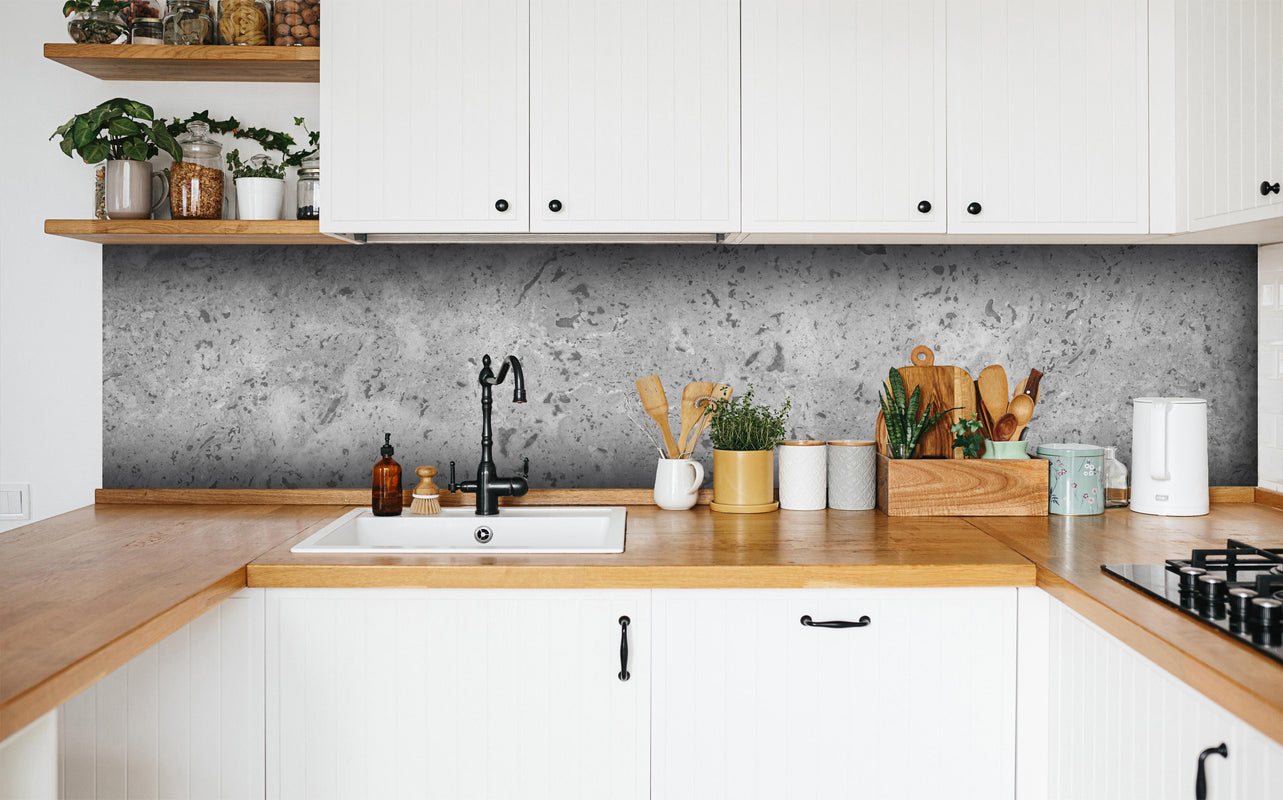 Küche - Grauer Beton in weißer Küche hinter Gewürzen und Kochlöffeln aus Holz