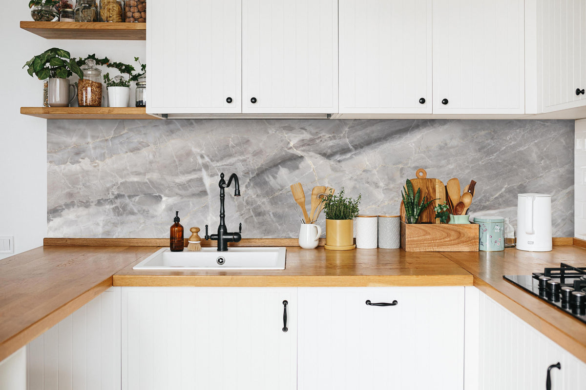 Küche - Grauer Marmor - Granit in weißer Küche hinter Gewürzen und Kochlöffeln aus Holz