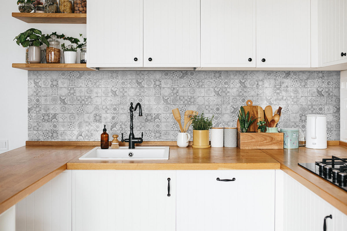 Küche - Graues weißes Mosaikmotiv in weißer Küche hinter Gewürzen und Kochlöffeln aus Holz