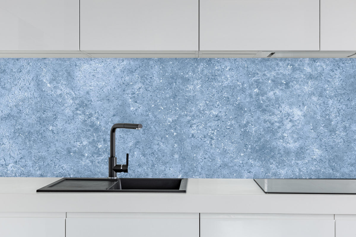 Küche - Hellblaue getünchte Wandtextur hinter weißen Hochglanz-Küchenregalen und schwarzem Wasserhahn
