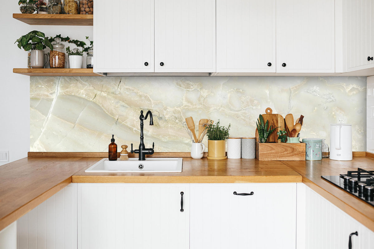 Küche - Hellweißer Marmor in weißer Küche hinter Gewürzen und Kochlöffeln aus Holz