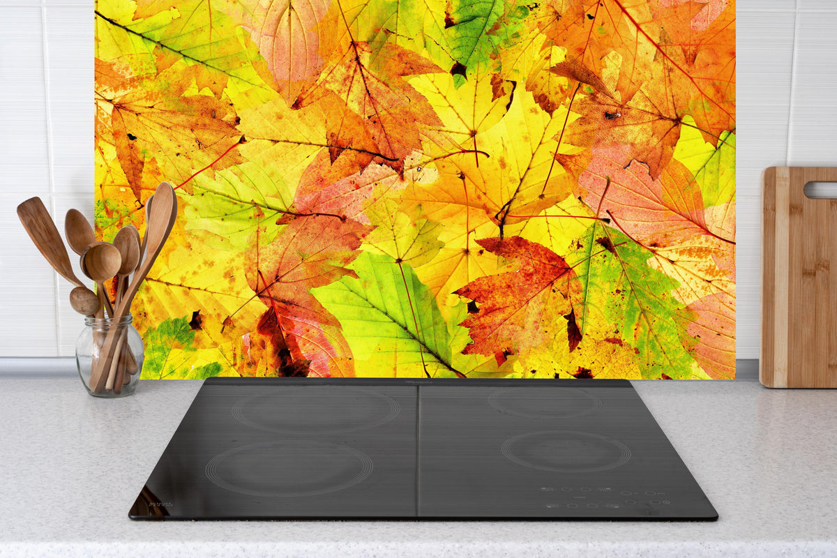 Küche - Herbstblätter Hintergrund hinter Cerankochfeld und Holz-Kochutensilien