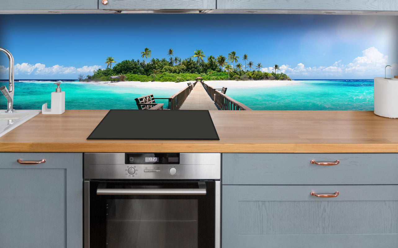 Küche - Holzsteg zur tropischen Insel über polierter Holzarbeitsplatte mit Cerankochfeld