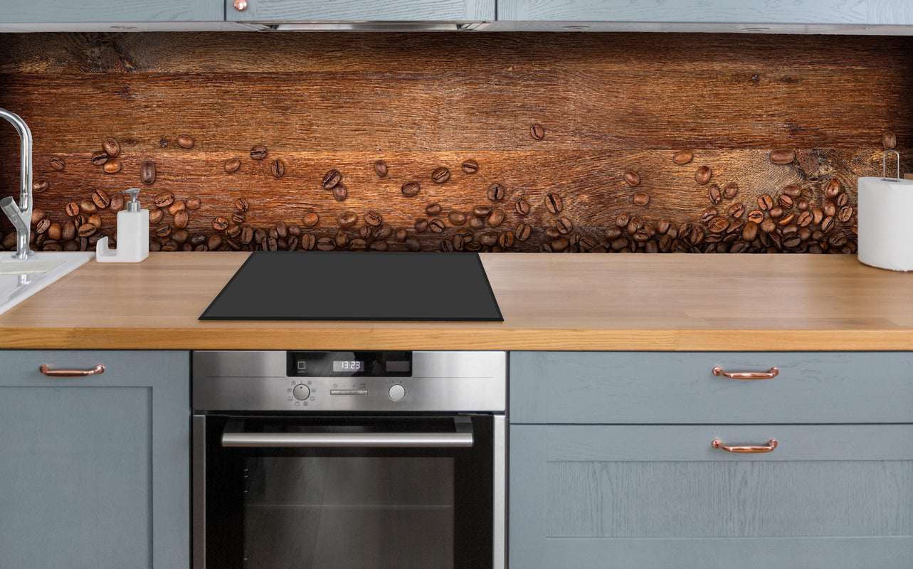 Küche - Kaffeebohnen auf Eichenholz über polierter Holzarbeitsplatte mit Cerankochfeld
