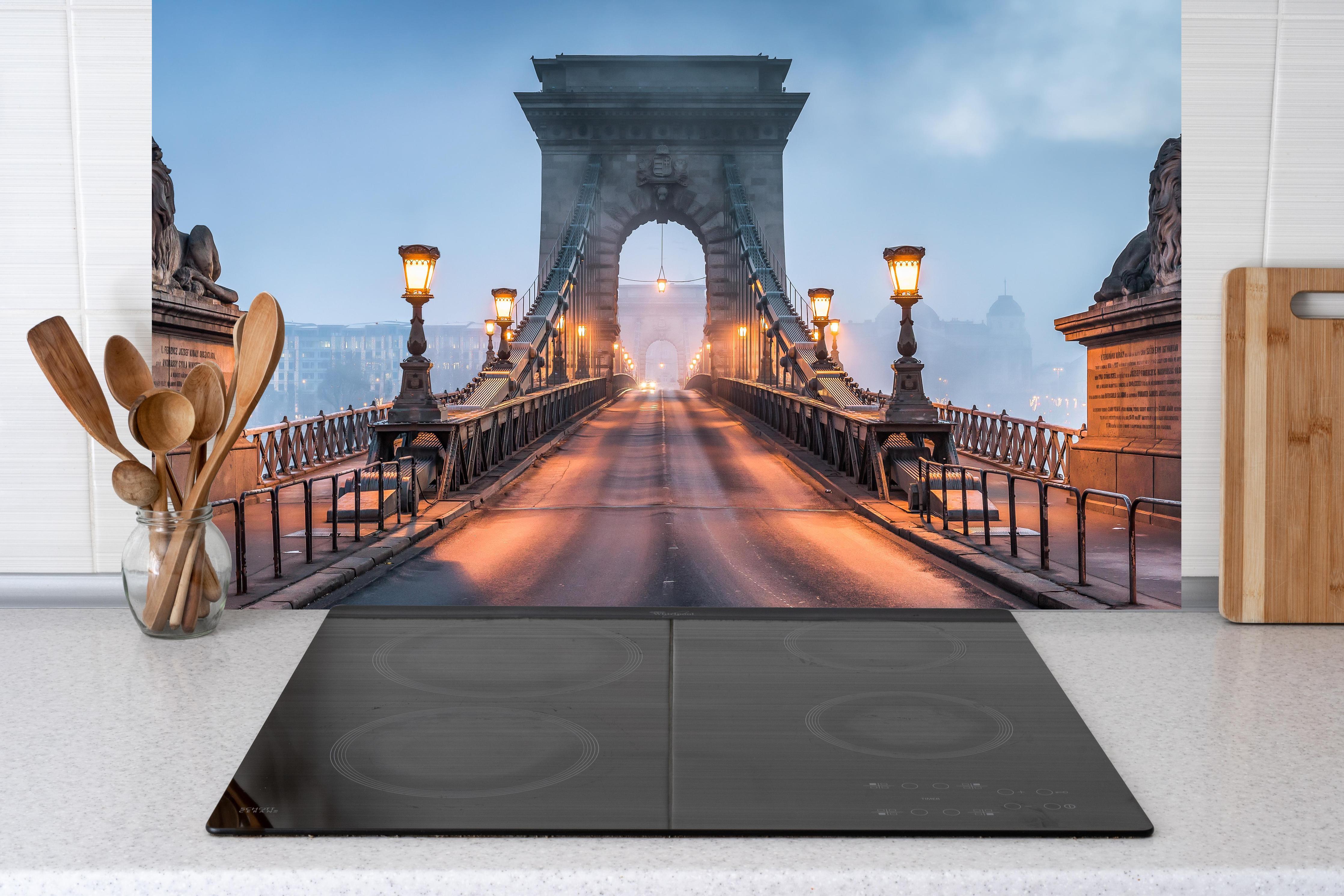 Küche - Kettenbrücke Panorama in Budapest hinter Cerankochfeld und Holz-Kochutensilien