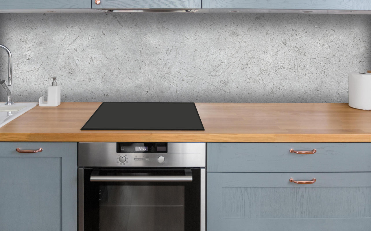 Küche - Kratzige graue Betonwand über polierter Holzarbeitsplatte mit Cerankochfeld