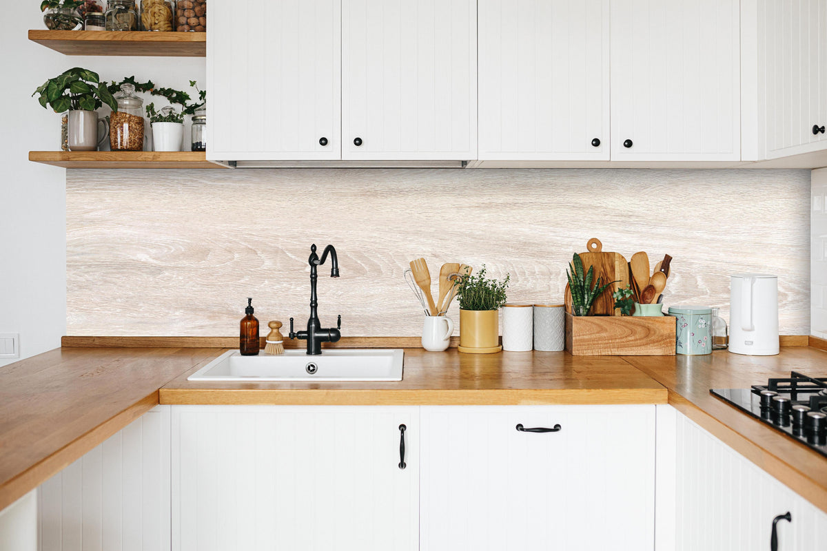 Küche - Lange beige Holzplatte in weißer Küche hinter Gewürzen und Kochlöffeln aus Holz