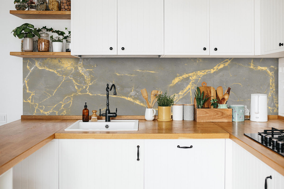 Küche - Luxuriöse Goldmarmor-Textur in weißer Küche hinter Gewürzen und Kochlöffeln aus Holz