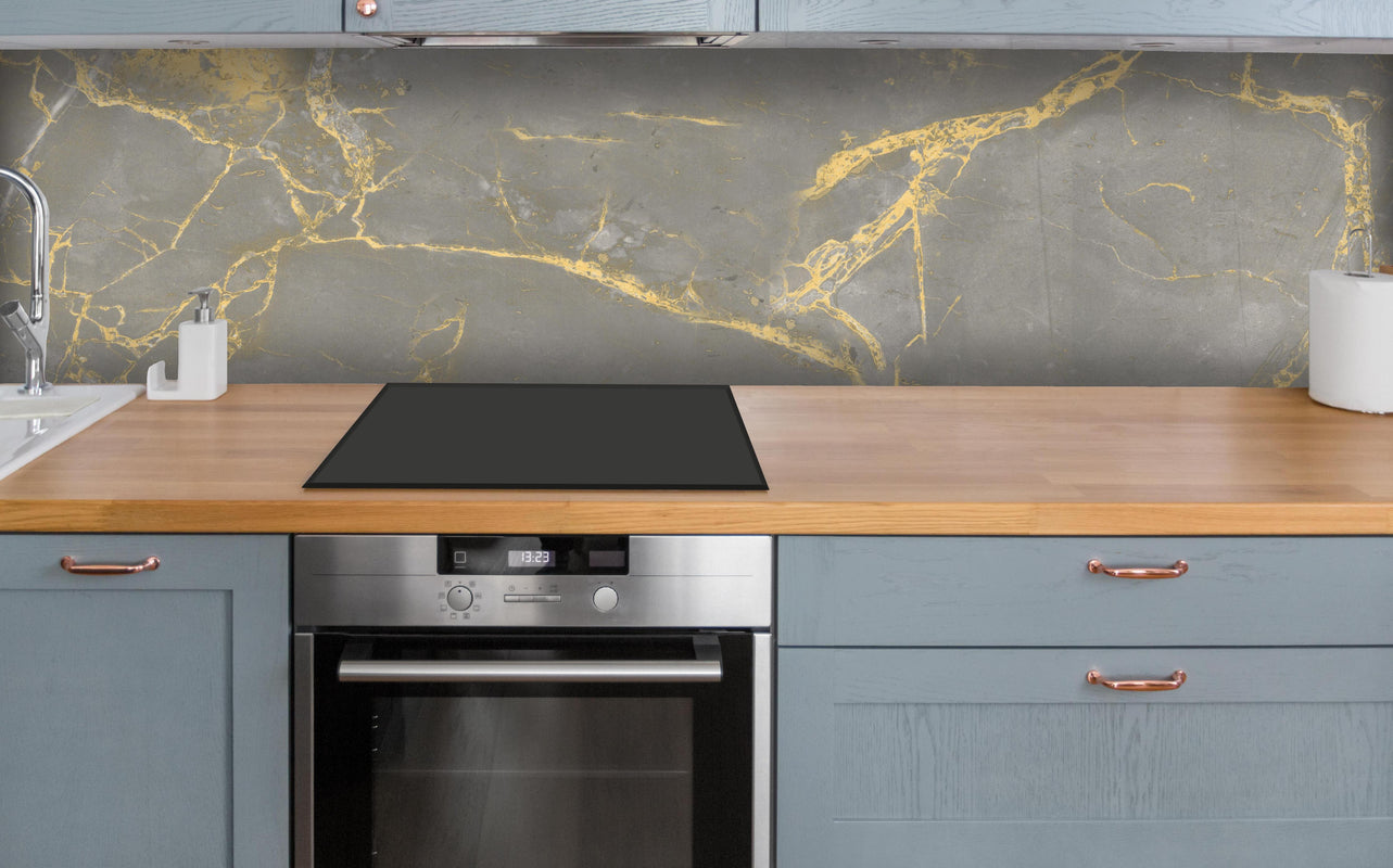 Küche - Luxuriöse Goldmarmor-Textur über polierter Holzarbeitsplatte mit Cerankochfeld