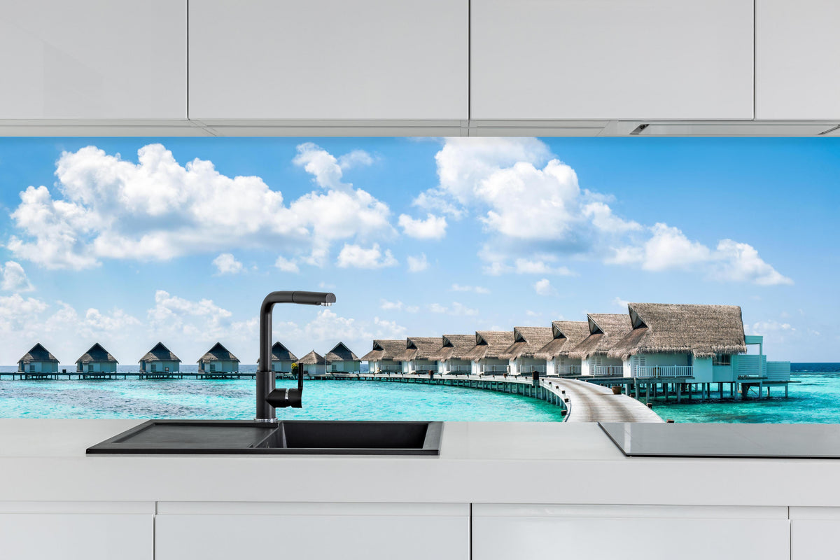 Küche - Malediven Wasser-Hotel hinter weißen Hochglanz-Küchenregalen und schwarzem Wasserhahn