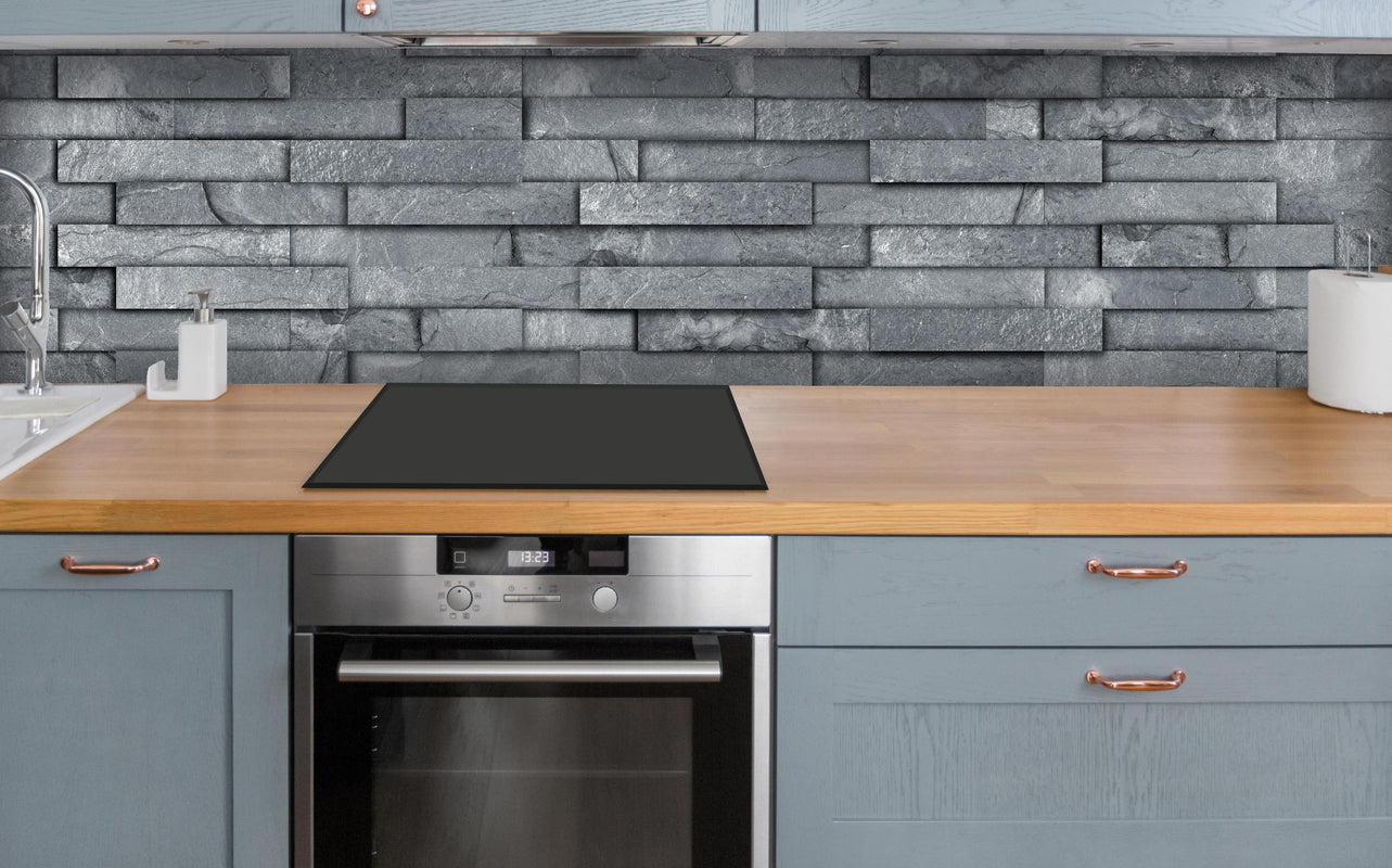 Küche - Nahtlose graue Schiefersteinwand Textur über polierter Holzarbeitsplatte mit Cerankochfeld