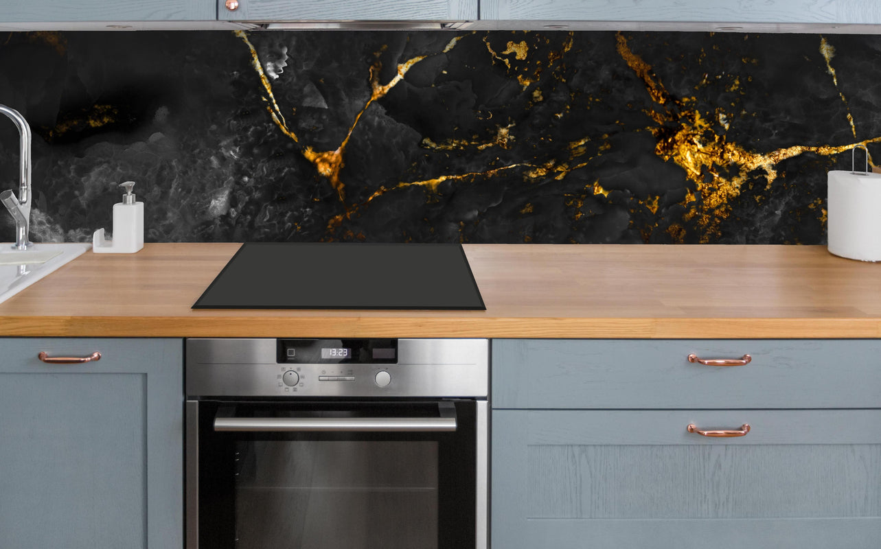 Küche - Natürliche schwarze Marmorstruktur mit goldenen Adern über polierter Holzarbeitsplatte mit Cerankochfeld