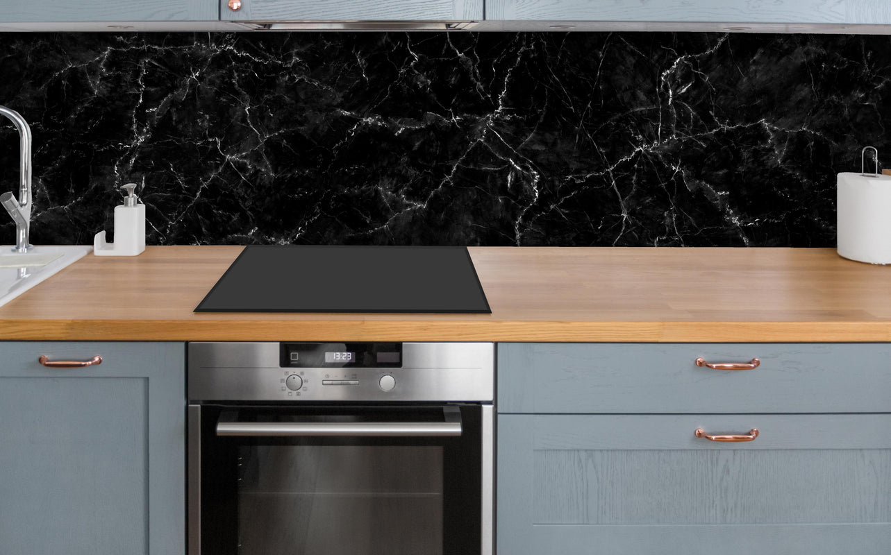 Küche - Natürlicher schwarzer Marmor über polierter Holzarbeitsplatte mit Cerankochfeld