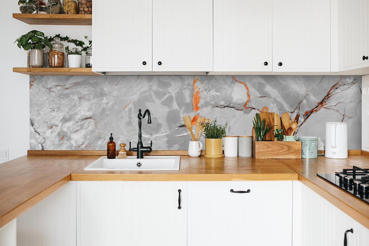 Küche - Orange-Weiß natürliche Marmortextur in weißer Küche hinter Gewürzen und Kochlöffeln aus Holz
