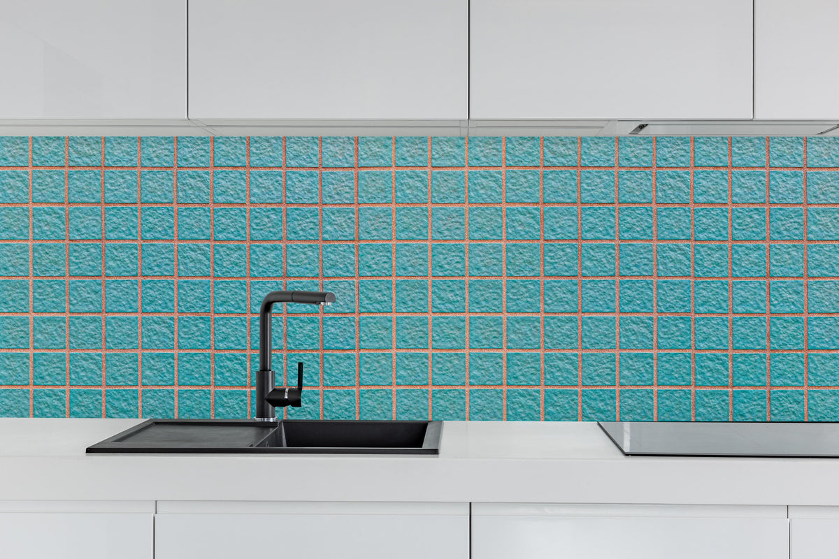 Küche - Panorama der hellblauen Steinblockwand hinter weißen Hochglanz-Küchenregalen und schwarzem Wasserhahn